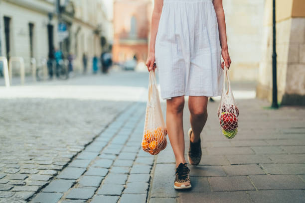 Woman with shopping bags walking down the street after shopping in the grocery store